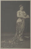 Large full-length photograph of the noted coloratura soprano in long dress with train, holding a fan, possibly a role portrait. With autograph inscription "Souvenir from Luisa Tetrazzini N.Y. 2 April 1911" in black ink running vertically along left portion of image