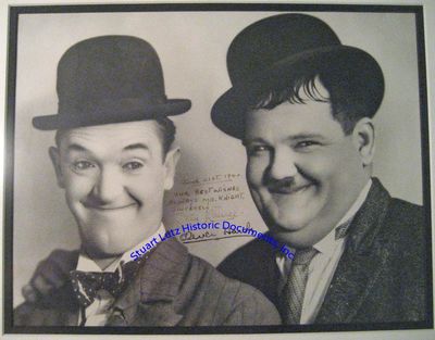 An Oversized Stan Laurel & Oliver Hardy Photograph, Showing Them In Their Trademark Bowler Hats