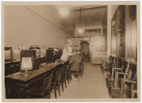 A photograph of the interior of the Optical Service Company as well as the proof copy of an advertisement for the business that was published in the St Louis Post-Dispatch