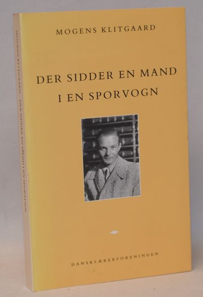 Der sidder en mand i en sporvogn.