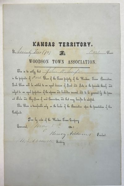 KANSAS TERRITORY. WOODSON TOWN ASSOCIATION. NO. SEVENTY TWO [72] ONE SHARE. THIS IS TO CERTIFY THAT JOHN H. SWIFT IS THE PROPRIETOR OF ONE SHARE OF THE TOWN PROPERTY OF THE WOODSON TOWN ASSOCIATION. EACH SHARE WILL BE ENTITLED TO AN EQUAL DIVISION OF LAND AND LOTS, OR THE PROCEEDS THEREOF, AND SUBJECT TO AN EQUAL PROPORTION OF THE EXPENSES AND LIABILITIES INCURRED, AND TO BE GOVERNED BY THE PRESENT RULES AND BY-LAWS OF SAID ASSOCIATION AND THAT MAY HEREAFTER BE ADOPTED. THIS SHARE IS TRANSFERABLE ONLY ON THE BOOKS OF THE ASSOCIATION UPON THE PRESENTATION OF THIS CERTIFICATE. DONE BY ORDER OF THE WOODSON TOWN COMPANY. GREENWOOD, MAY 5TH, 1856. [signed] HENRY ADDOMS, PRESIDENT. [signed] W.S. BREWSTER, SECRETARY