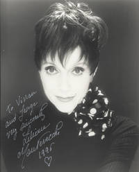 Bust-length photograph of the French-born actress, dancer, and singer, inscribed and signed in full in silver ink, dated 1996