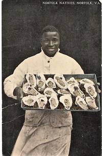 NORFOLK NATIVES: TINTED, REAL-PHOTO POSTCARD OF AN AFRICAN-AMERICAN CHEF DISPLAYING A LARGE TRAY...