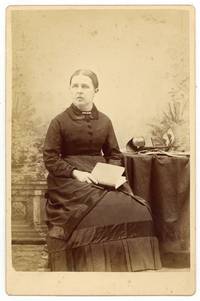 [Cabinet card photograph]: Middle-aged Woman with a book, stereoviewer, and stereo cards. Circa 1980