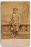 [Cabinet Card photograph]: Well-Dressed Young African-American Boy Standing at Attention with a Toy Rifle and Wearing a military Kepi Cap
