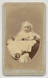 [Photograph]: Infant In White Dress sitting on a cushion, cheeks highlighted with pink, identified in pencil in lower margin as "Lzole. G. Thornton
