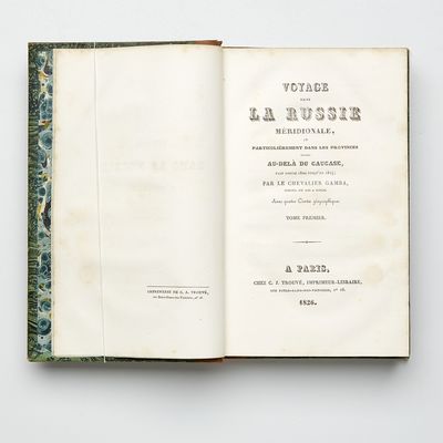 Voyage dans la Russie Méridionale, et particulièrement dans les provinces situées au-delà du Caucase, fait depuis 1820 jusqu`en 1824; Volume I-II in 8vo + Atlas in Folio (331 x 252 mm). Paris, C. J. Trouvé, 1826. Text volumes : (4) + IX + 444; (4) + 480 pp. 4 folding maps, one coloured in outline. 1 folding table. Text with occasional spotting. Atlas volume : 60 lithographic and engraved plates, of which 34 hand-coloured, one plate foxed and with tear. Uniformily bound in contemporary half calf. Gilt spines. Upper joints partly cracked. Bookplate (Gösta Nobel). Stamp with barionial crown and monogram G S on first fly-leafs. Complete, with the rare atlas volume. (photo 3)