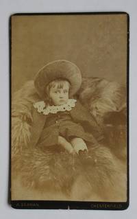 image of Carte De Visite Photograph: Studio Portrait of a Young Child with a Bonnet on a Fur Rug.